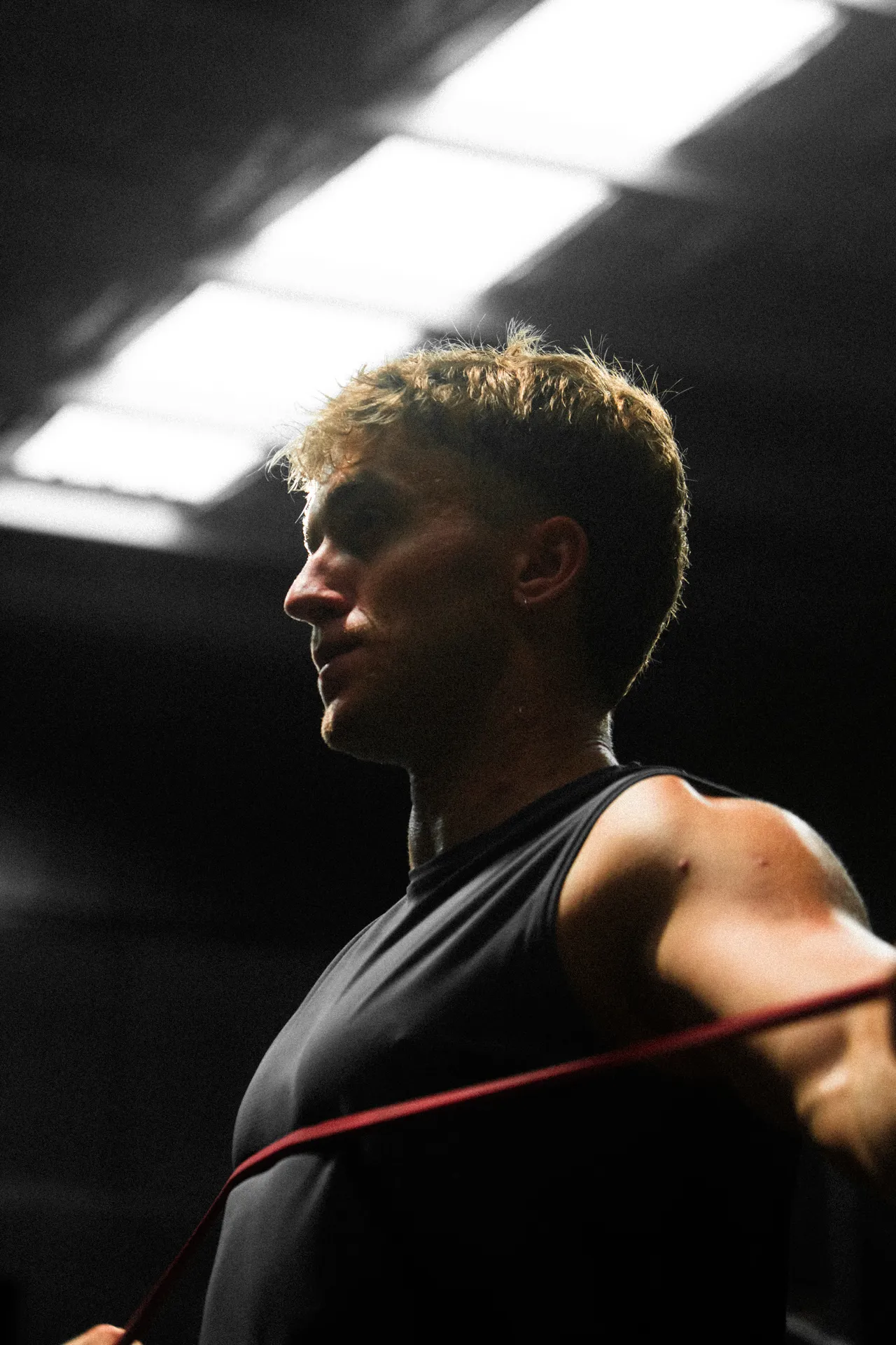 Felix training with a resistance band in a low-lit gym